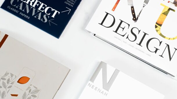 Design books and paper layout samples, evoking early desktop publishing and page design