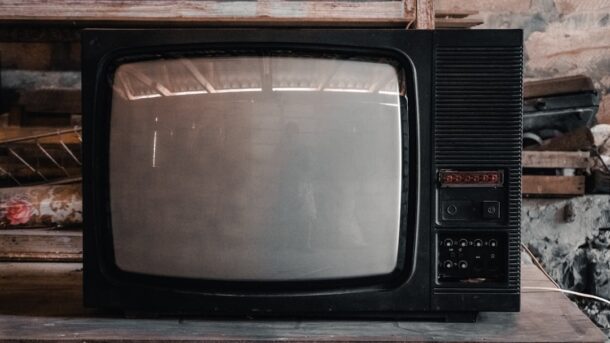 An old vintage television set on a wooden shelf, evoking the early era of electronic television
